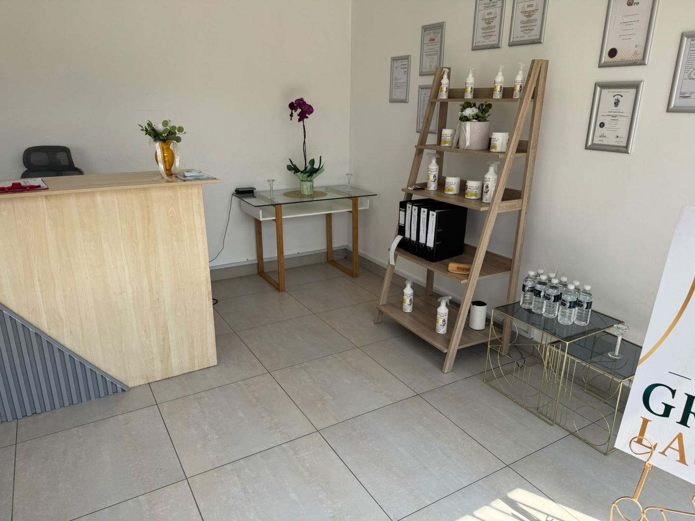 Med-Pro reception desk with a retail shelf of wellness products and framed certificates